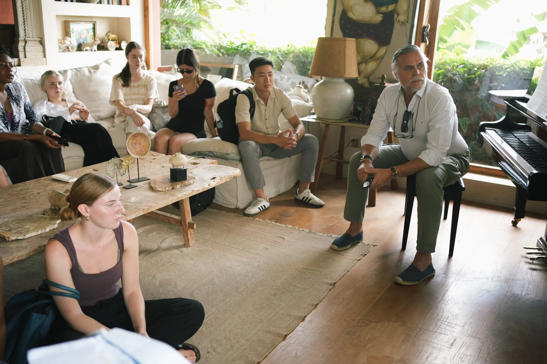 Felipe Gonzalez speaking to a seated group of students in a living room at Nenek Coco Villa