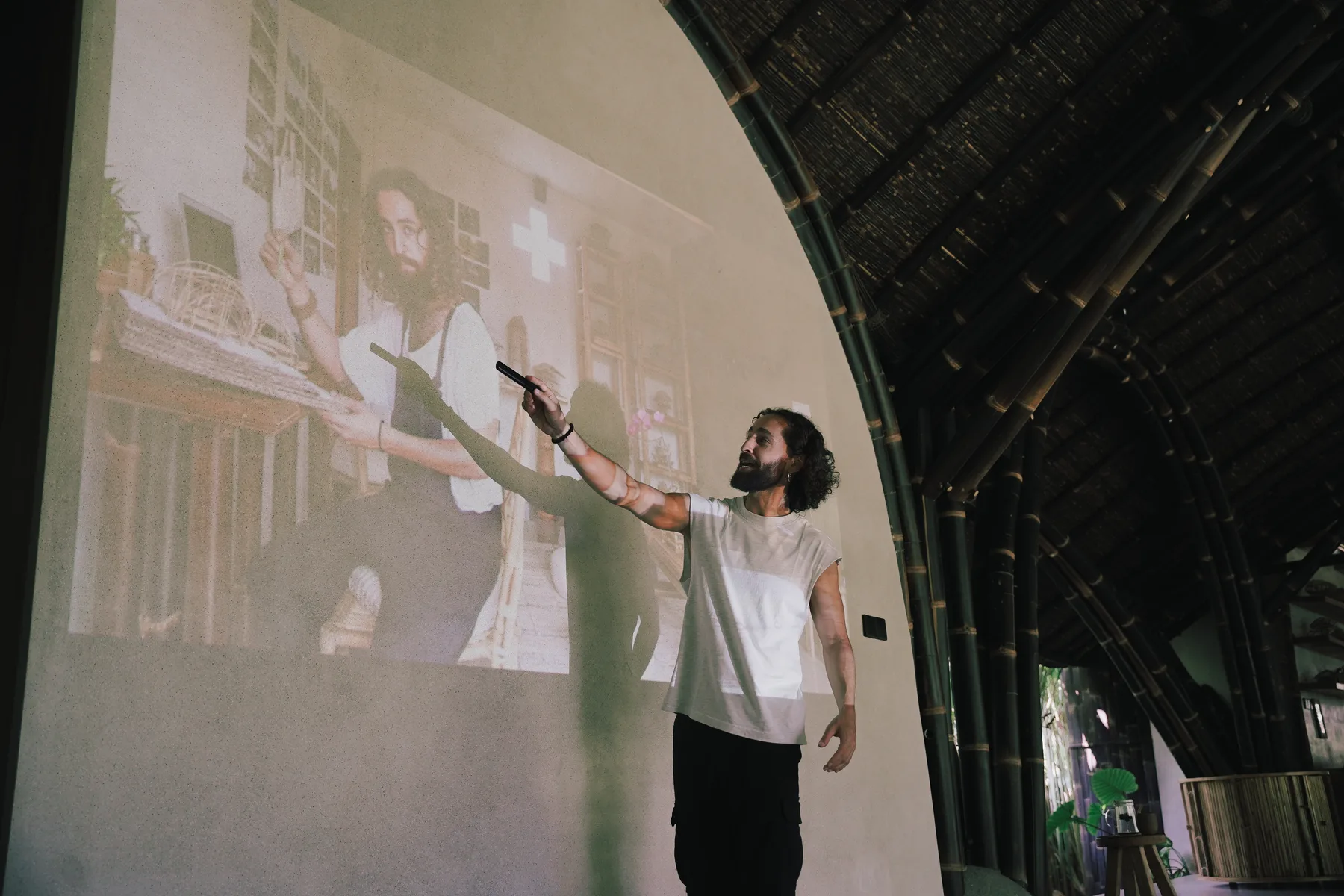Architect Pablo Luna pointing at a projected drawing of one of his bamboo projects while presenting to the group