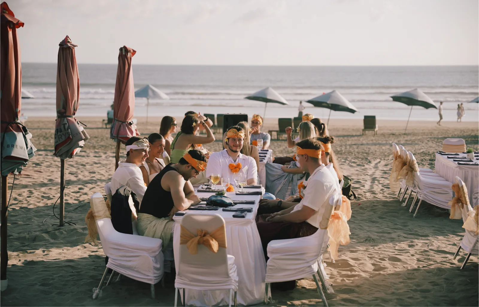 Dinner tables set up on the sand in front of the sea
