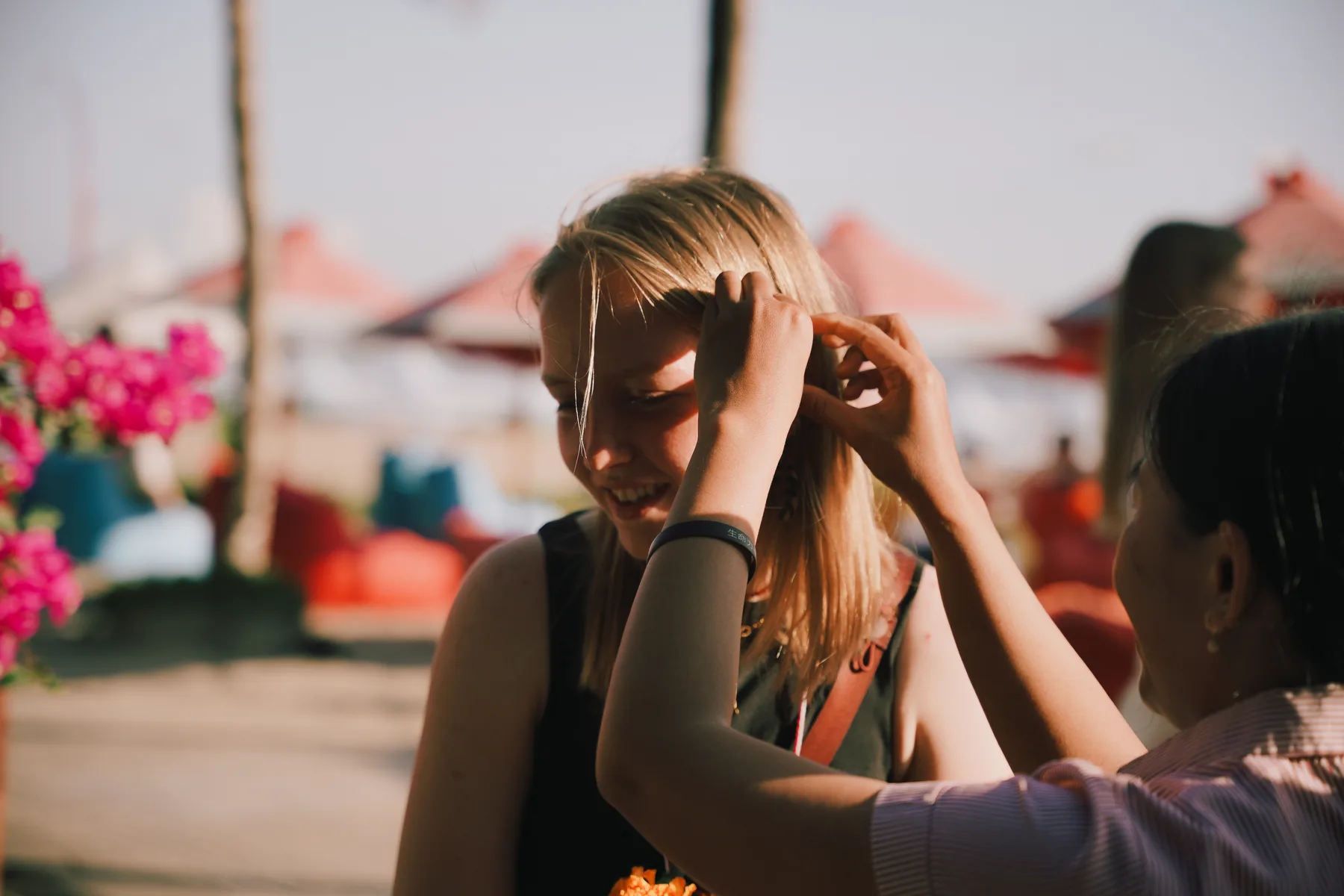 A staff member adjusting a flower in a student's hair before the dinner