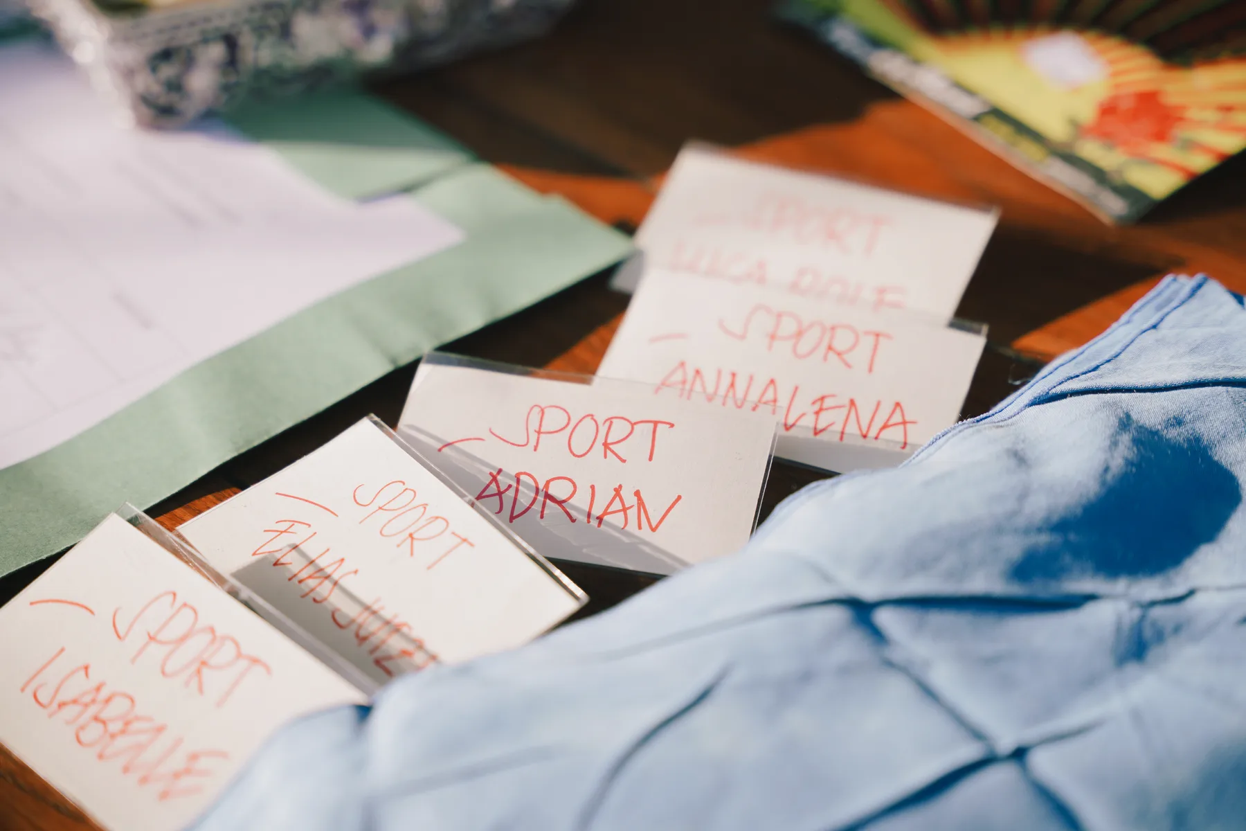 Handwritten name tags laid out on a table, each marked with a program and a first name