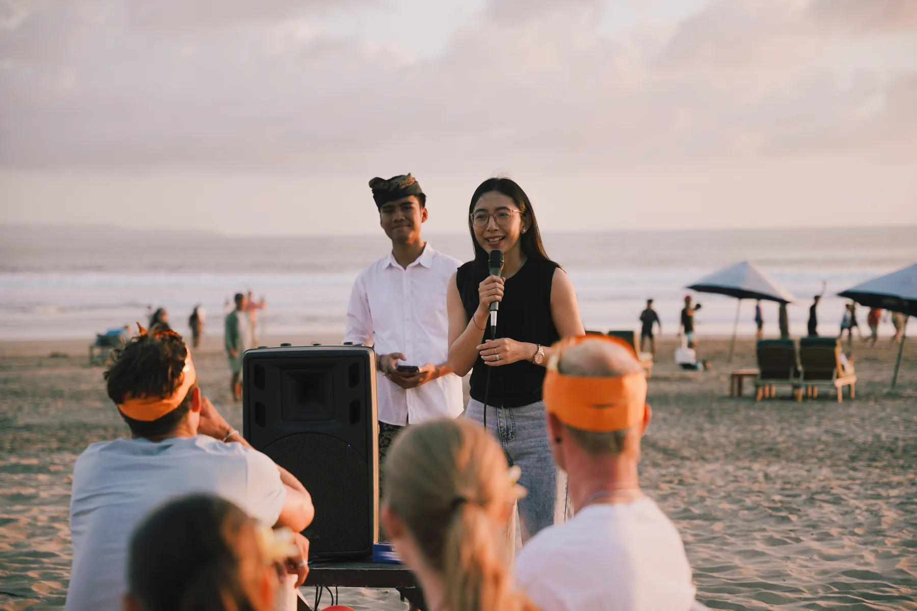 Two staff members introducing the evening with a microphone, students seated in the foreground