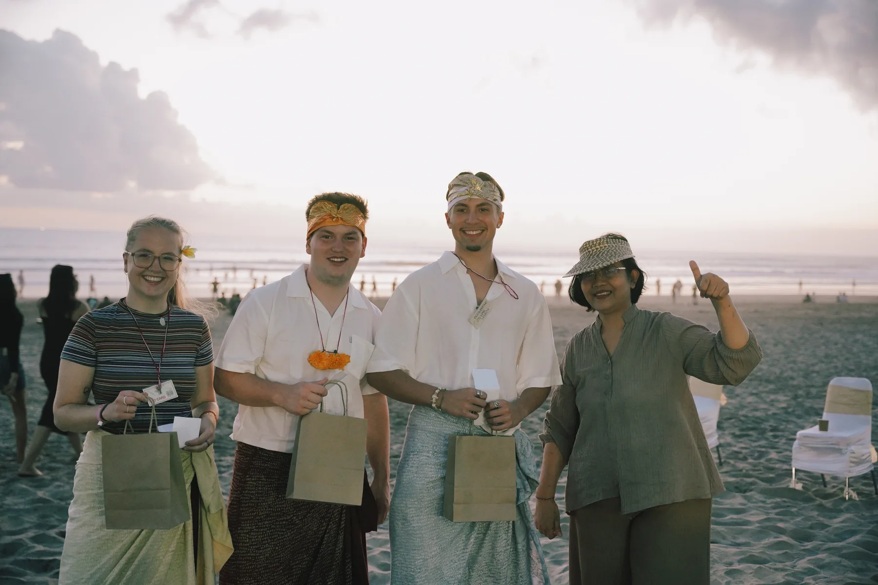 A group of students holding welcome gift bags, posing with a staff member