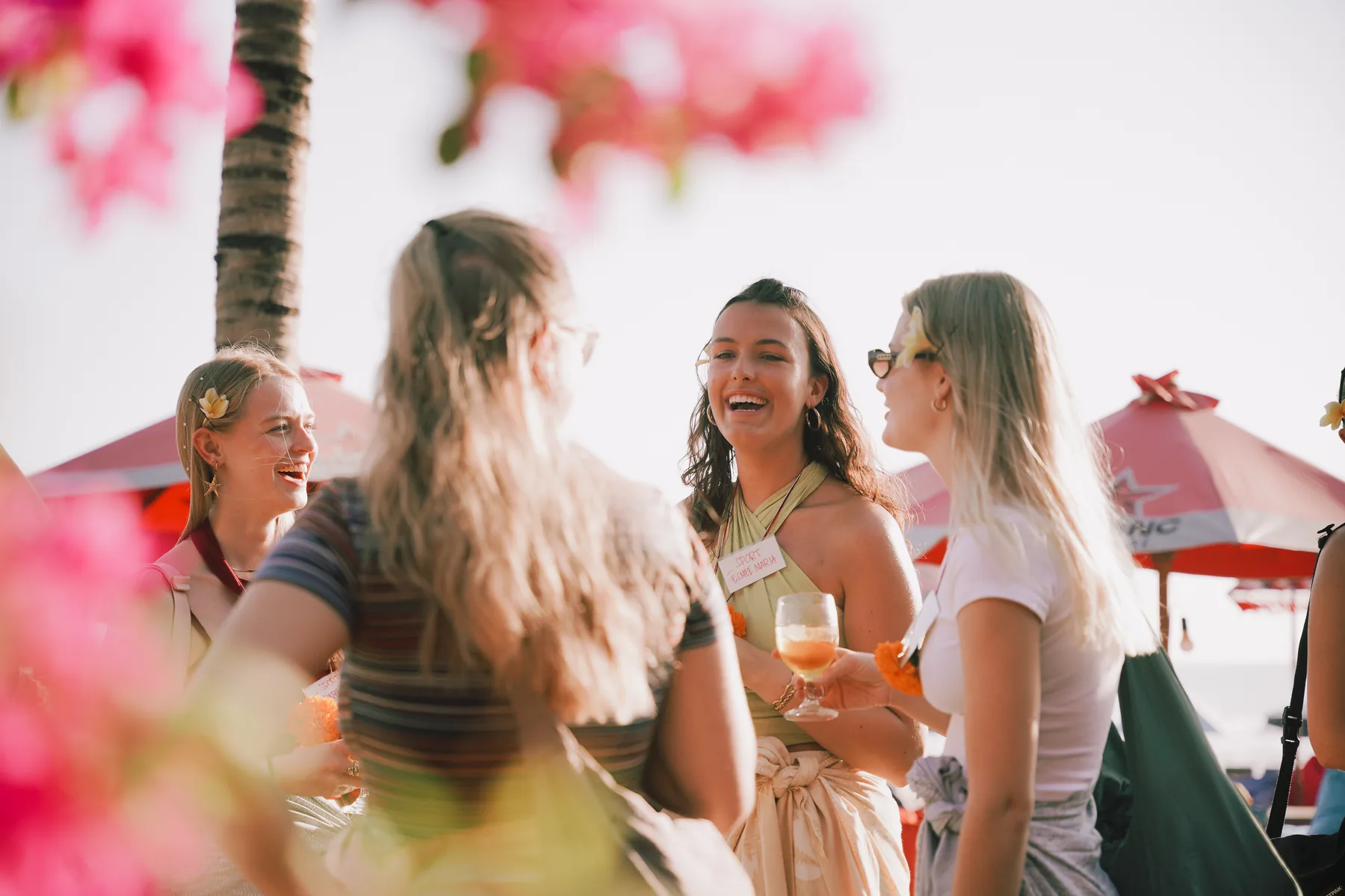 Students arriving at the Welcoming Dinner on the beach, name tags on, drinks in hand