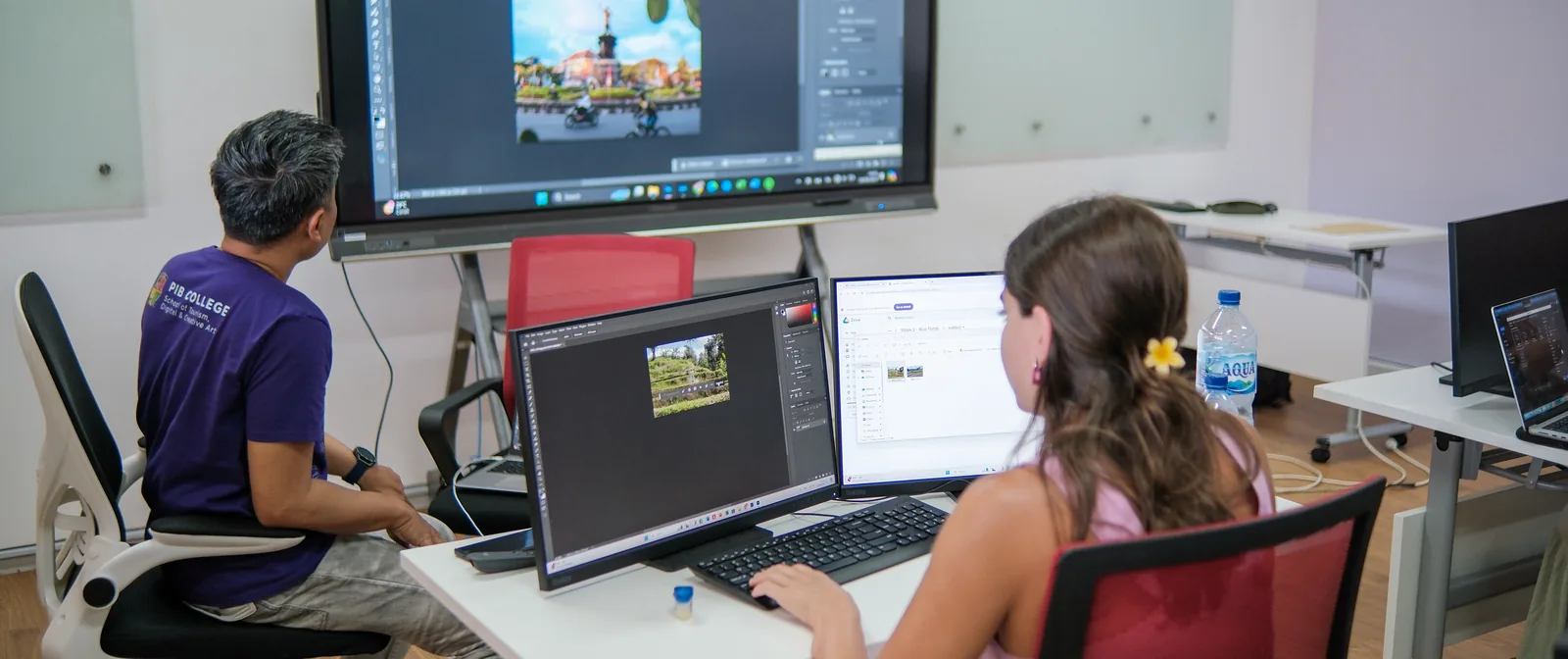 Student curating her photographs on screen with an instructor at the editing suite